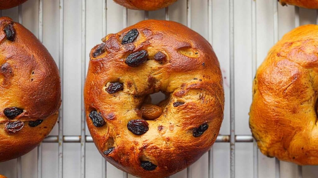 Close-up of golden-brown cinnamon raisin bagels cooling on a wire rack

