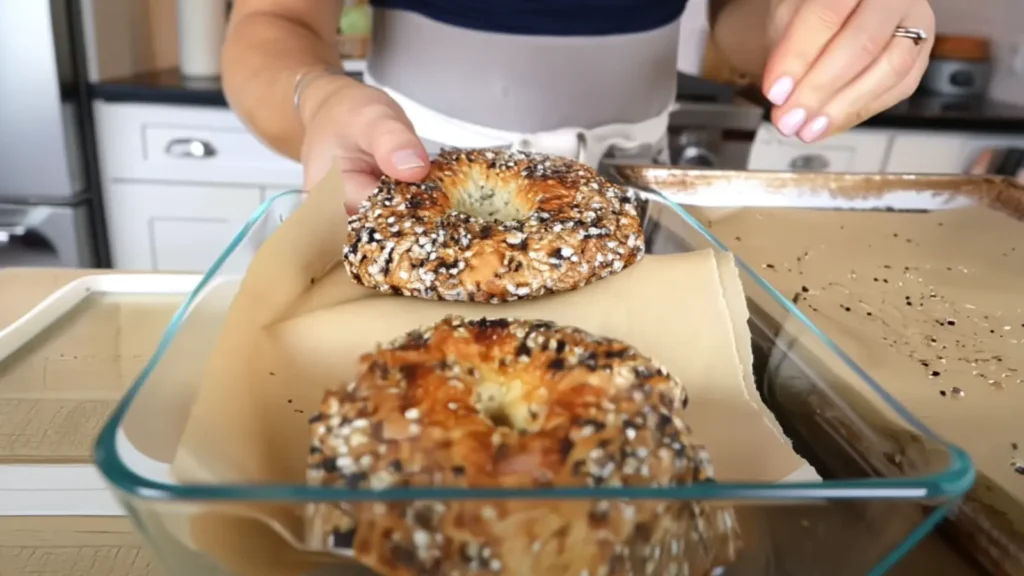 Freshly baked cottage cheese bagels being placed into a glass container
