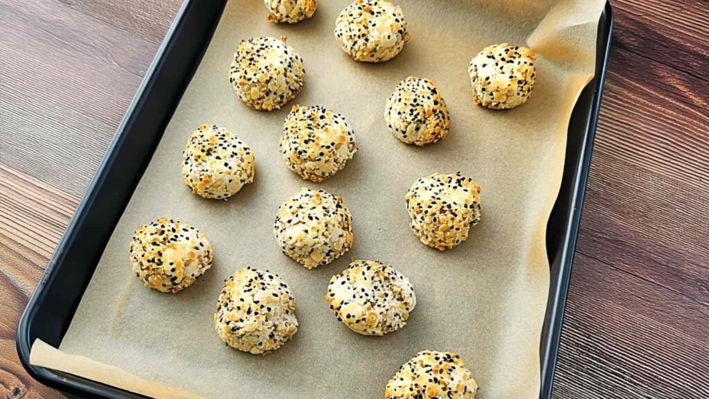 Unbaked high-protein bagel bites arranged on parchment-lined tray