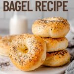 Hero shot of stacked bagels with “High Protein Bagel Recipe” text overlay on a bright kitchen background.