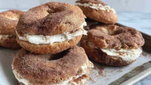Close-up of a cinnamon sugar bagel filled with cream cheese, showing its golden crust coated in cinnamon and sugar.