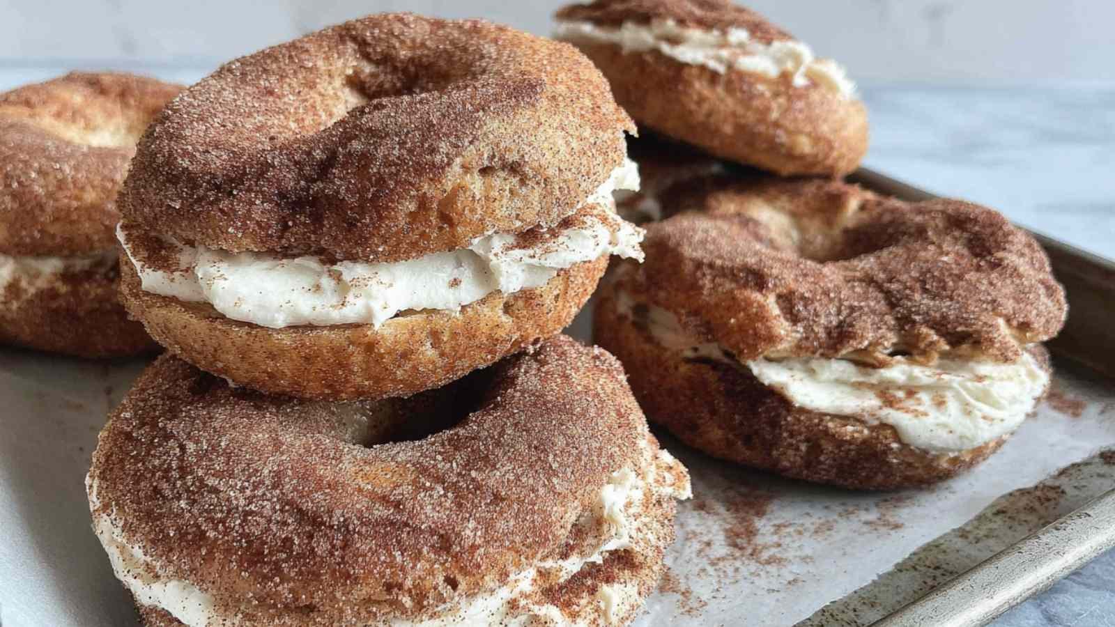 Close-up of a cinnamon sugar bagel filled with cream cheese, showing its golden crust coated in cinnamon and sugar.
