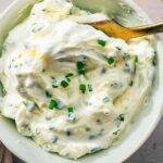 Bowl of homemade chive cream cheese with visible chopped chives and creamy texture, ready to serve