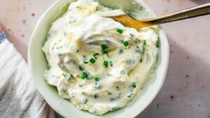 Bowl of homemade chive cream cheese with visible chopped chives and creamy texture, ready to serve