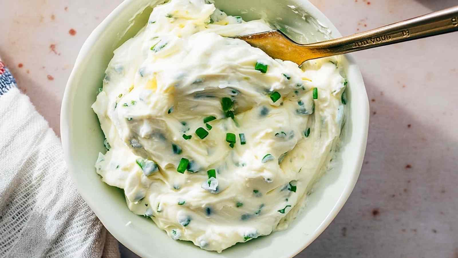 Bowl of homemade chive cream cheese with visible chopped chives and creamy texture, ready to serve
