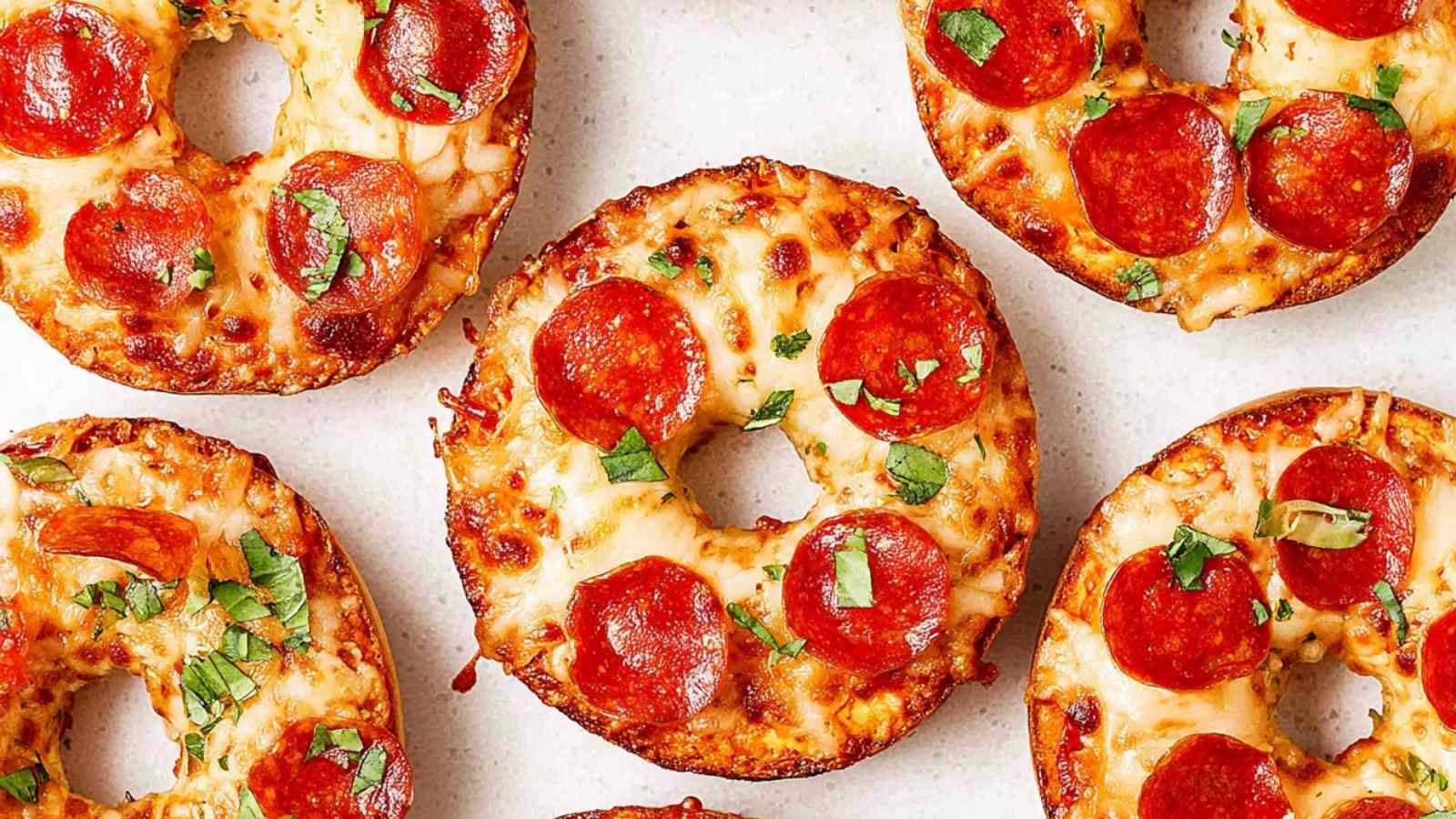Close-up of crispy pizza bagels topped with melted mozzarella, pepperoni, and fresh basil, cooked in an air fryer.
