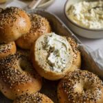 Sourdough discard protein bagels, one sliced and topped with whipped cream cheese
