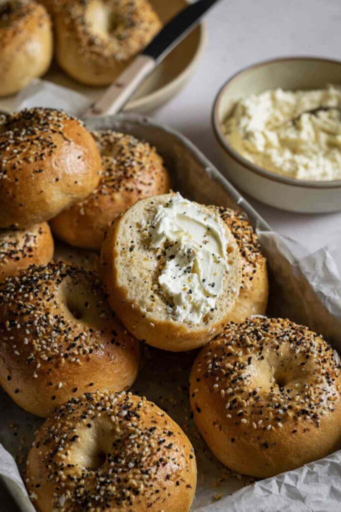 Sourdough discard protein bagels, one sliced and topped with whipped cream cheese