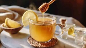 Glass of natural zepbound drink with honey drizzle and lemon wedge on rim
