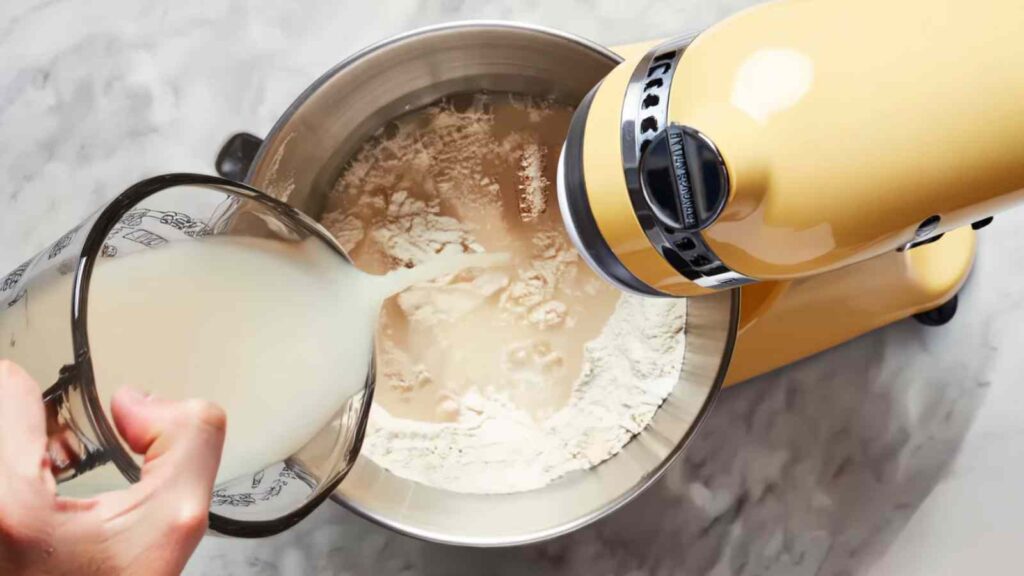 Mixing flour and water for Paul Hollywood's bagel dough in a stand mixer.
