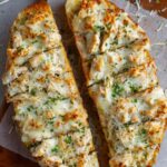 Chicken alfredo garlic bread sliced and ready to serve with melted cheese