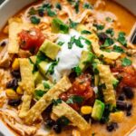 chicken taco soup in bowl with toppings