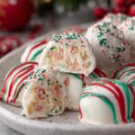 Little Debbie Christmas Tree Cake Truffles with white chocolate coating and red drizzle on parchment paper