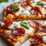Hot honey flatbread pizza with melted cheese and pepperoni drizzled with spicy honey