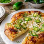 Jalapeño Popper Pizza with melted cheese and fresh jalapeños on pizza stone