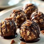No bake pecan pie balls coated in graham cracker crumbs on white plate
