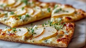 Pear and Gorgonzola flatbread with walnuts and arugula on baking sheet