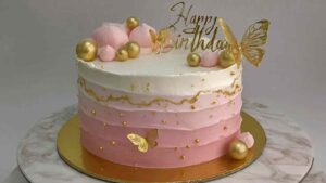 Pink butterfly birthday cake with ombre buttercream and gold decorations