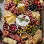Holiday charcuterie board with Brie, grapes, crackers, olives, blackberries, and sliced meats arranged around a central wheel of cheese on wood board