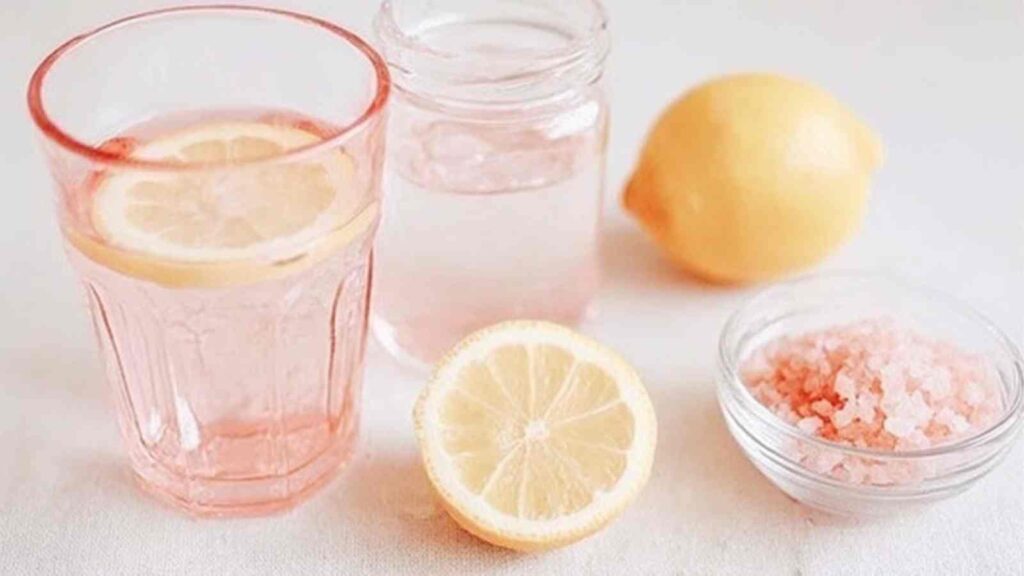 Pink salt lemon water 13 Two glasses of pink salt lemon water with lemon slices and pink salt bowl, ready to drink