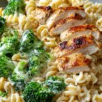 creamy rotisserie chicken broccoli pasta in white bowl with fork
