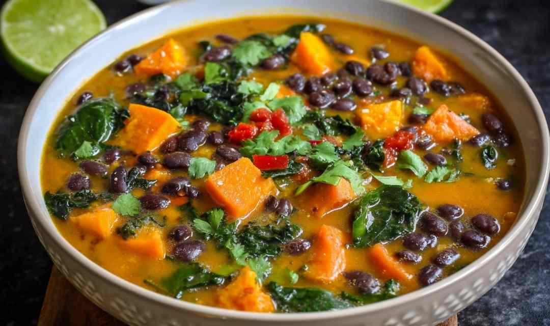 Black bean sweet potato soup in white bowl topped with cilantro and tortilla chips