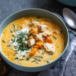 Bowl of creamy chicken sweet potato soup with tender chicken pieces and spinach in velvety broth