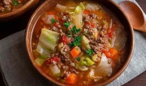 Ground Beef and Cabbage Soup Ground beef and cabbage soup in large pot with vegetables