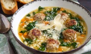 Easy Italian Wedding Soup Bowl of Italian wedding soup with mini meatballs, orzo pasta, and spinach garnished with Parmesan cheese