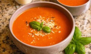 High Protein Tomato Soup with Cottage Cheese Bowl of high protein tomato soup with cottage cheese garnished with fresh basil and parmesan