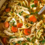 Bowl of easy chicken noodle soup with egg noodles, carrots, celery, and fresh herbs