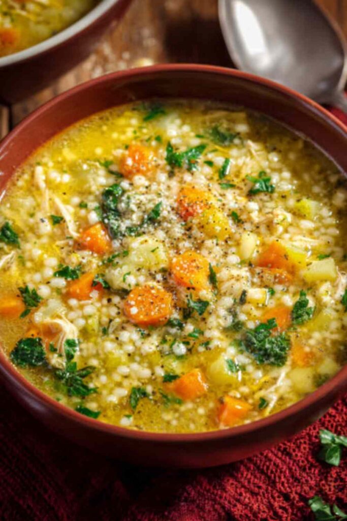 Bowl of Italian penicillin soup with chicken, vegetables, and pasta in golden broth