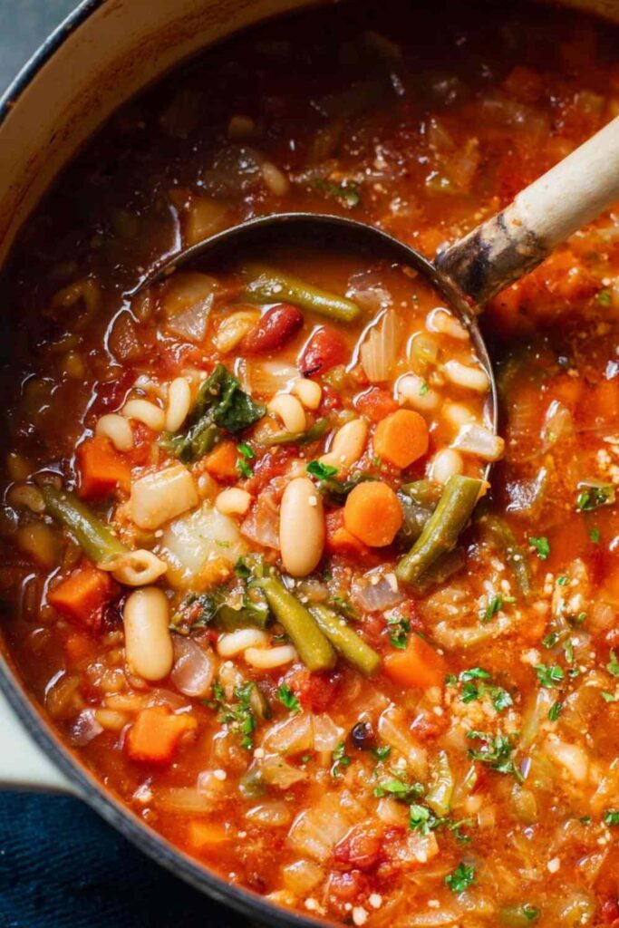 Minestrone Soup Recipe 4 Large pot of minestrone soup recipe cooking on stovetop with vegetables and pasta