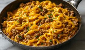 one-pot creamy beef and garlic butter pasta in skillet with melted cheese