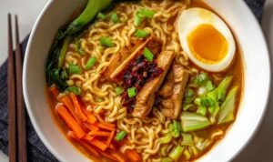 Tasty Ramen Noodle Soup Recipe Homemade ramen noodle soup with shredded chicken and vegetables in white bowl