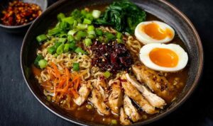 Vegan Vegetable Noodle Soup Bowl of vegan vegetable noodle soup with angel hair noodles and fresh parsley garnish