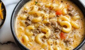 Bowl of Cheeseburger Macaroni Soup topped with shredded cheese and croutons