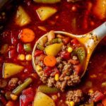 Hearty cowboy soup with ground beef and vegetables in white bowl