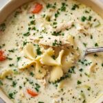 Bowl of creamy chicken alfredo soup garnished with fresh parsley and grated parmesan cheese