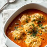Bowl of Tomato Soup with Cheddar Bay Dumplings garnished with fresh herbs