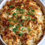 French onion chicken orzo casserole in skillet with melted cheese and caramelized onions