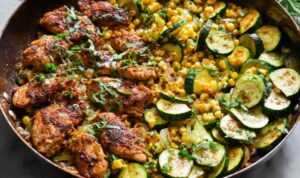 Garlic Butter Chicken with Zucchini and Corn in a cast-iron skillet