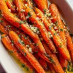 Honey Garlic Butter Roasted Carrots on white serving platter with parsley