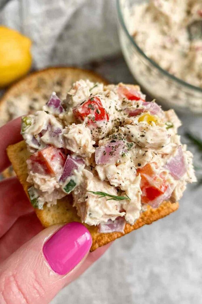 Italian Grinder Chicken Salad served in a bowl with crackers and fresh vegetables