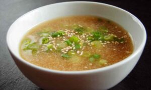 Lemon ginger miso soup in bowl with sesame seeds and green onion garnish