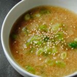 Lemon ginger miso soup in bowl with sesame seeds and green onion garnish