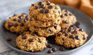 Stack of oatmeal peanut butter protein cookies with chocolate chips on white plate