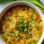 One-pot egg roll soup in white bowl topped with green onions and sesame seeds