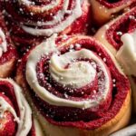 Red velvet cinnamon rolls with white glaze on festive plate