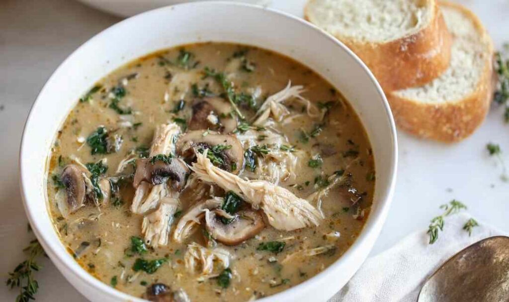 Rotisserie chicken mushroom soup in white bowl with fresh herbs garnish
